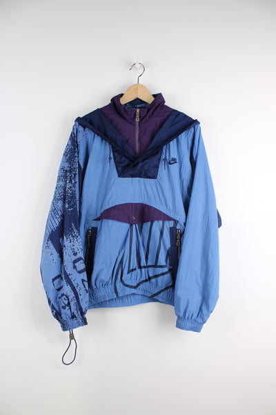 Vintage 90's Nike blue and purple nylon pullover lightweight jacket, features zip up pockets, embroidered logo on the chest and abstract graphic down the sleeves