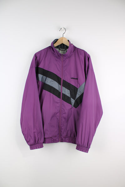 Vintage purple Adidas zip through nylon shell track top, features embroidered logo on the chest and geometric motif on the front
