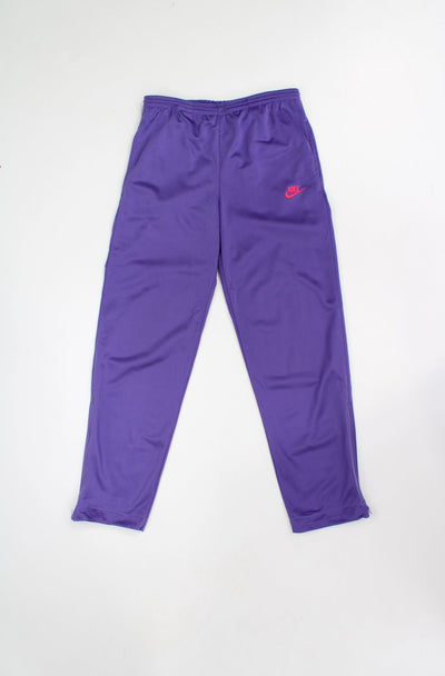 Vintage 90's Nike purple tracksuit bottoms with pink embroidered logo on the pocket and zip up cuffs