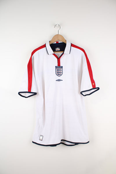England 2003/05, Umbro Reversible Football Shirt in a white and red and also has a white and blue striped colourway options, V-neck with with collar, and has logos embroidered on the front.