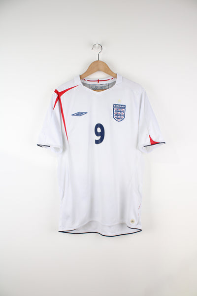 England 2005/07, Umbro Football Shirt in a white colourway, has Wayne Rooney number 9 printed on the back, V-neck with little collar, and has logos embroidered on the front.