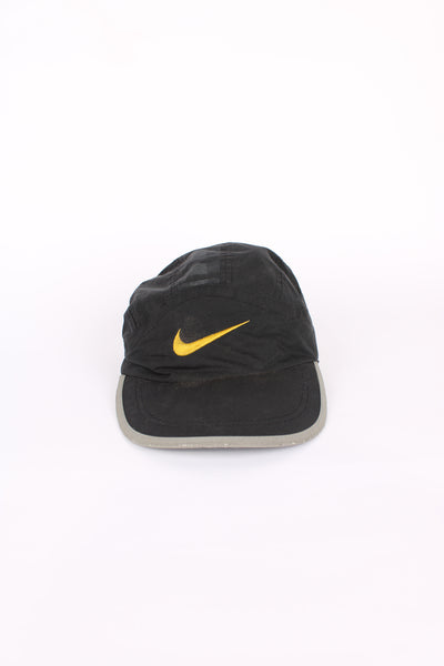 90's Nike cap in black, 100% polyester, adjustable strap, and yellow swoosh on the front.