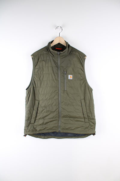 Carhartt workwear padded gilet in green, full zip up, multiple pockets, and has the logo embroidered on the front. 