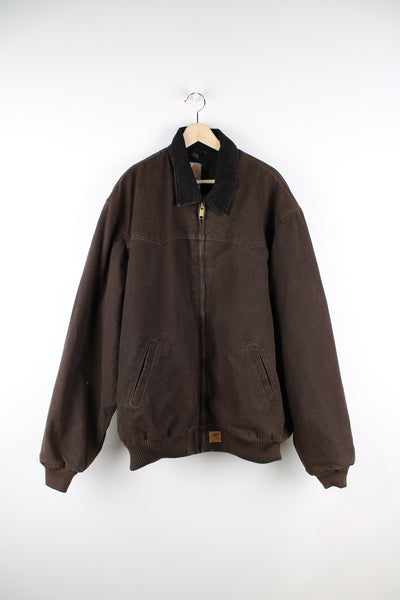 Vintage Carhartt Santa Fe Jacket in brown, has a black corduroy collar, heavy collar lining, and logo embroidered on the front. 