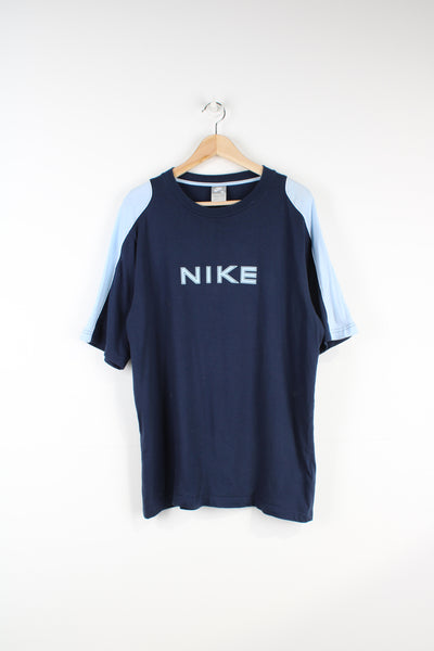 00's Nike t-shirt in a navy blue, with light blue detail on the arms. Features printed spellout logo on the chest.  good condition - some bobbling around the neck and light mark on the shoulder (see photos) Size in Label: Mens XL
