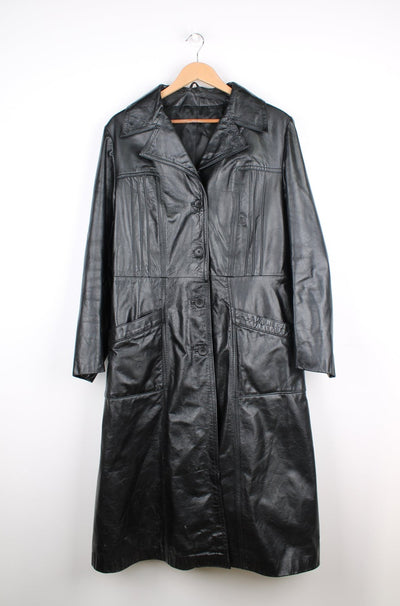 Vintage all black leather trench coat with belt, closes with buttons down the front and has pleated details on the chest  