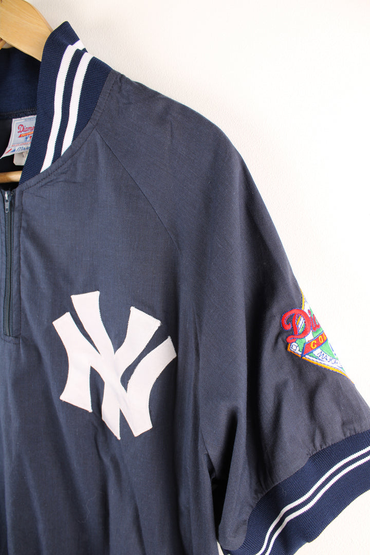 Vintage MLB New York Yankees short sleeve drill top in the blue and white team colourway, quarter zip up, has embroidered logos on the front and sleeves. 
