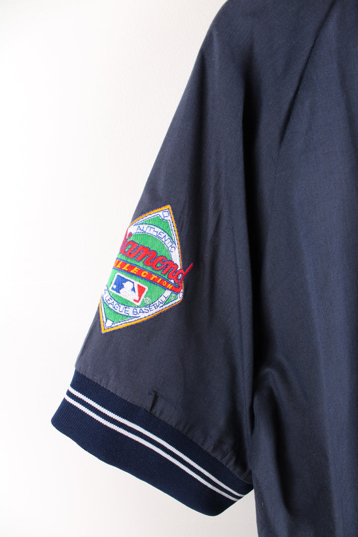 Vintage MLB New York Yankees short sleeve drill top in the blue and white team colourway, quarter zip up, has embroidered logos on the front and sleeves. 