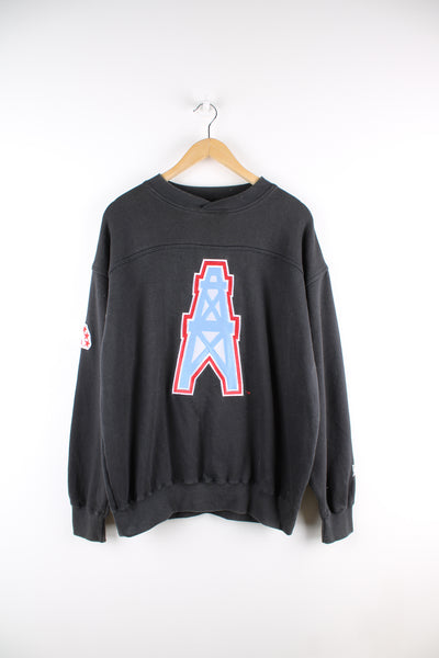 Vintage NFL Houston Oilers sweatshirt in black, has the team logo  and spell out embroidered on the front, sleeve and back of the sweat. 