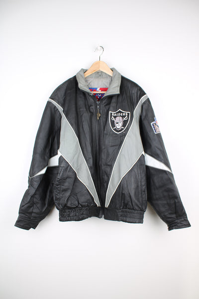 90's Oakland (now Las Vegas) Raiders Leather leather varsity style bomber jacket with embroidered Raiders patch on the chest and back. Made by Pro Player by Daniel Young. good condition - light discoloration and scratches to the white parts of the leather (see photos)