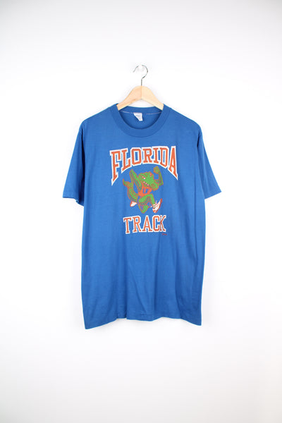 Vintage 80's Florida Track blue t-shirt. Features printed graphic on the front and single stitch seams on the sleeves. good condition - some cracks to the graphic (see photos) Size in Label:  Mens L - Measures more like a M 