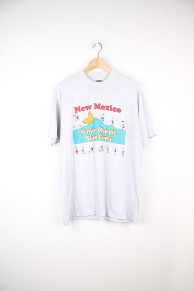 New Mexico, Senior Olympic State Games T-Shirt in a grey colourway with cartoon sport graphic design printed on the front, fruit of the loom label and is single stitch.