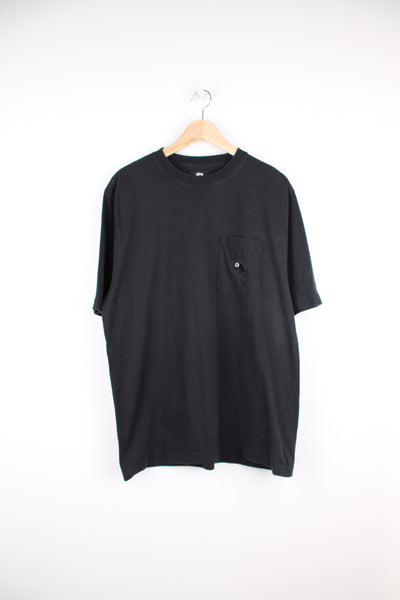All black Stussy t-shirt features embroidered 8-ball on the chest pocket
