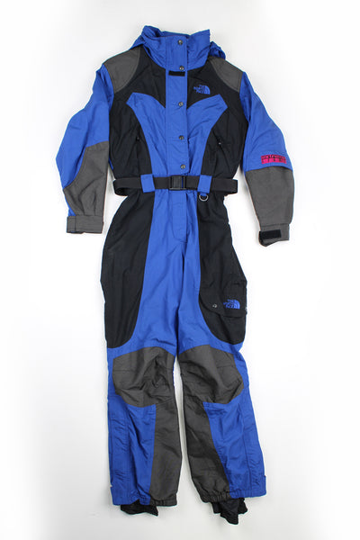 Vintage blue and black North Face outdoor/ ski suit, with padding, elasticated waistband/ belt and hood.  good condition - some of the popper buttons are stiff to close.  Size in Label:  Womens size 4 (XXS)