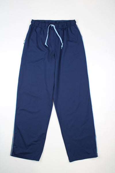 Vintage Nike tracksuit bottoms in a blue colourway, elasticated waist, and has logos embroidered on the front.