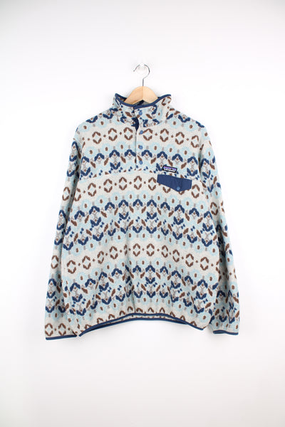 Patagonia Synchilla Fleece in a patterned blue, white and brown colourway, quarter button up, chest pocket, and has logo embroidered on the front.