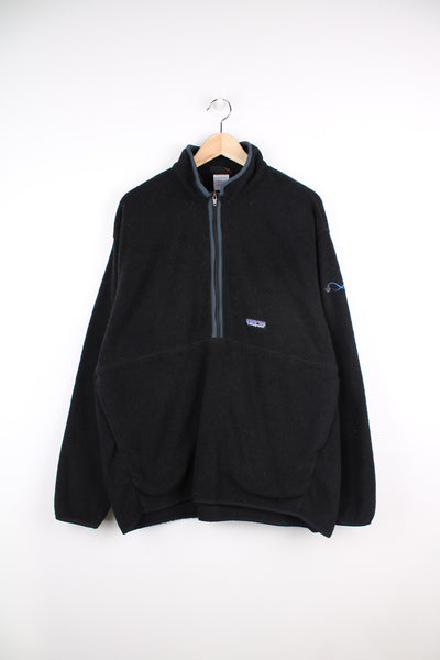 Patagonia Synchilla Fleece in a black colourway, half zip up, big pouch pocket and has a construction logo embroidered on the left sleeve as well as the Patagonia logo on the front.