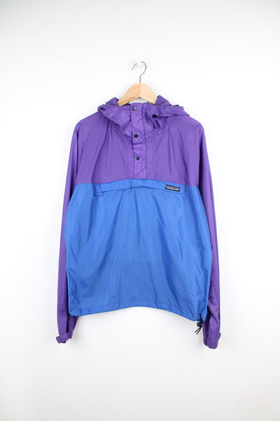 Vintage Patagonia Pullover Windbreaker in a purple and blue colourway, hooded, big pouch pocket, and has the logo embroidered on the front.