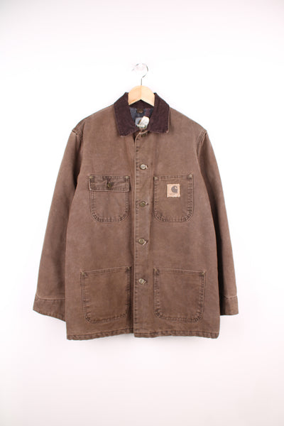 Carhartt Chore Jacket in a brown colourway, corduroy collar, blanket lining, button up, multiple pockets and has the logo embroidered on the front.