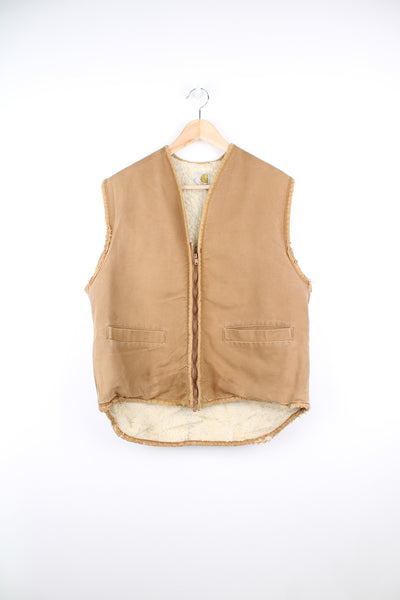 Vintage Carhartt Workwear Gilet in a tan / faded brown colourway, distressed / thrashed style, zip up, and has a sherpa lining.