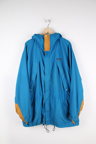 Patagonia Torrentshell outdoor jacket in blue, zip up, multiple pockets, hooded and has embroidered logo on the front.