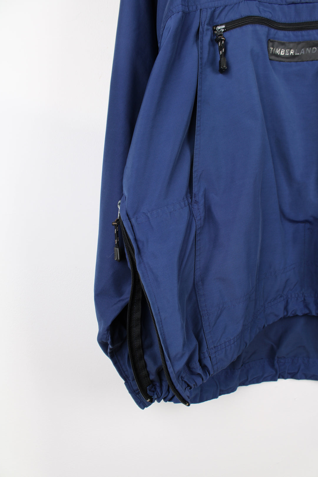 Vintage Timberland pullover jacket in blue, has 3m reflective stripes on the shoulders, multiple pockets, quarter zip up, and has logos embroidered on the front and back.