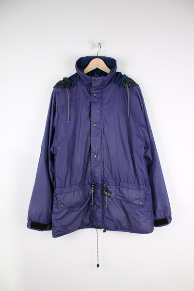 Vintage Rab Downpour waterproof jacket in purple, zip up, multiple pockets, hooded and has logo embroidered on the front. 