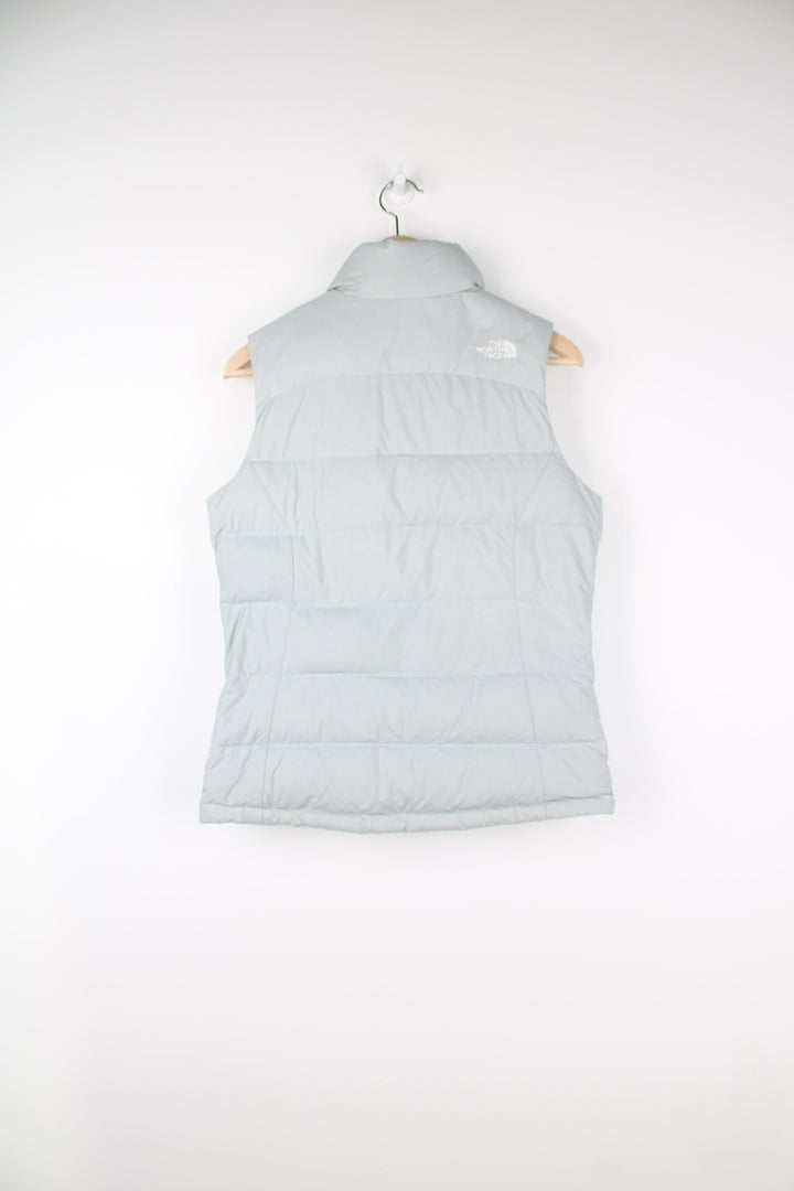 The North Face Face puffer gilet in a grey, zip up with side pockets, insulated and has logo embroidered logo on the front and back.