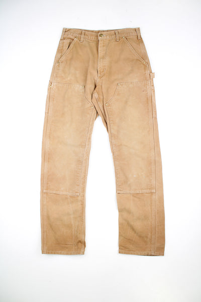 Carhartt Double Knee Jeans in a tan colourway, multiple pockets, and has the logo embroidered on the back pocket.