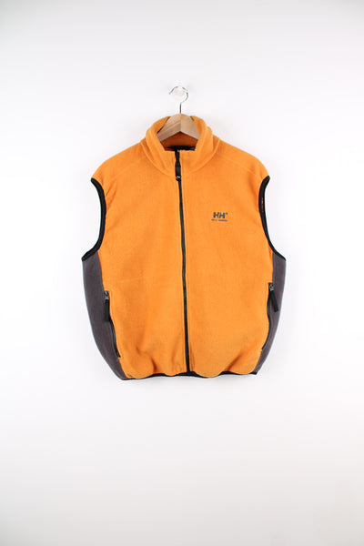 Helly Hansen Fleece Vest in a orange and grey colourway, zip up, side pockets, and has the logo embroidered on the front and the back of the collar.
