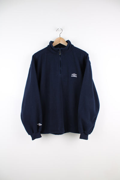 Umbro Pullover Fleece in a blue colourway, quarter zip, side pockets, adjustable waist and has the logo embroidered on the front.