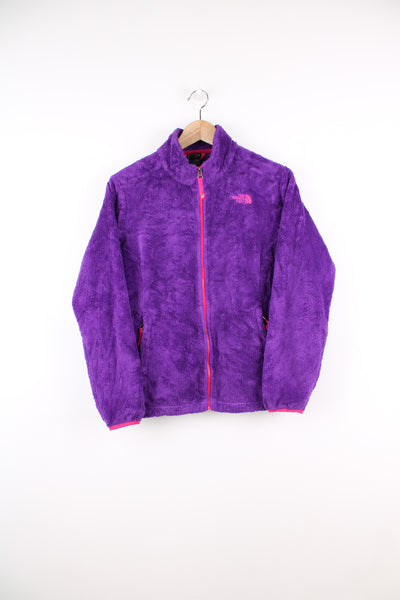 The North Face Fleece in a purple colourway, zip up, side pockets, and has the logo embroidered on the front.