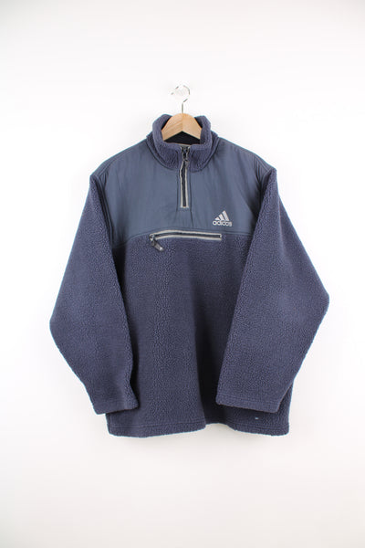 Adidas Pullover Fleece in a grey colourway, quarter zip, pouch pocket, and has the logo embroidered on the front and back of the collar.