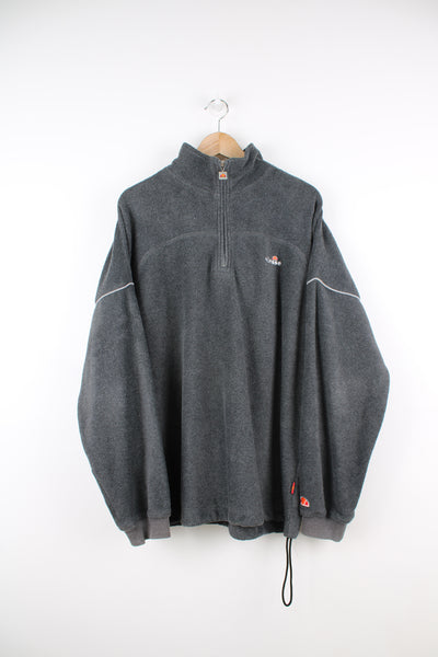Ellesse Pullover Fleece in a grey colourway, quarter zip, adjustable waist and has the logo embroidered on the front and left sleeve.