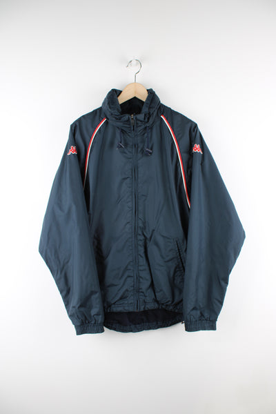 Vintage Kappa lightweight waterproof jacket in blue, zip up, has a hidden hood, side pockets and logo embroidered on the sleeves. 