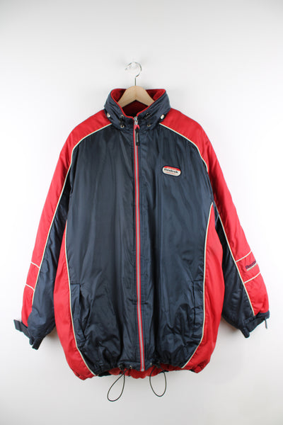 Vintage Reebok Athletics Sports Coat in a blue and red colourway, zip up, has a hidden hood, insulated with a quilted lining, and has logo embroidered on the front. 