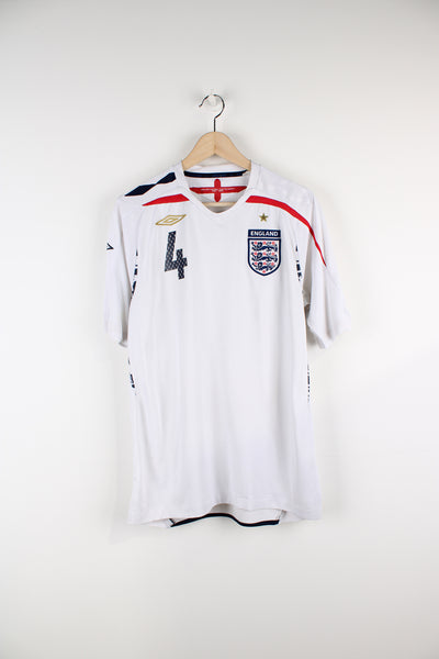Vintage England 2007/09, Umbro Home Football Shirt, white, blue and red colourway, v neck, Steven Gerrard number 4 printed on the back and has printed logos on the front. 