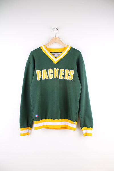 Green Bay Packers, Russel Athletic Sweatshirt in a green, yellow and white team colourway colourway, v neck, and has the name spell out printed on the front.