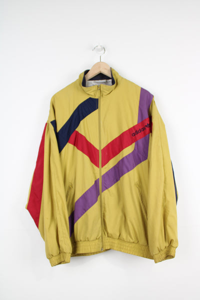 Vintage 1990s Adidas mustard yellow shell jacket with embroidered geometric patterns and logo on chest 