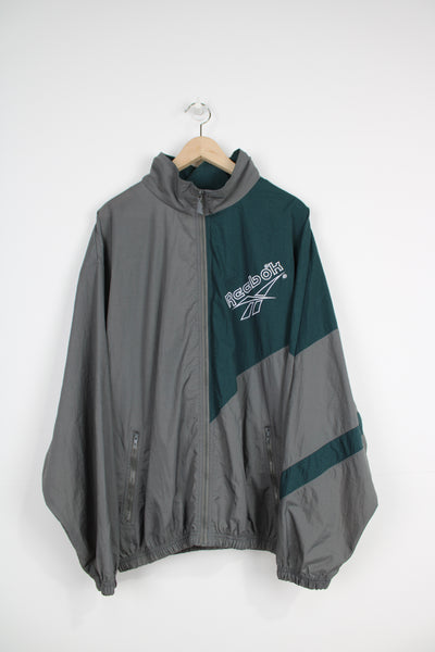 Vintage 90's Reebok grey and green zip through shell jacket with embroidered logo on the chest and back with foldaway hood