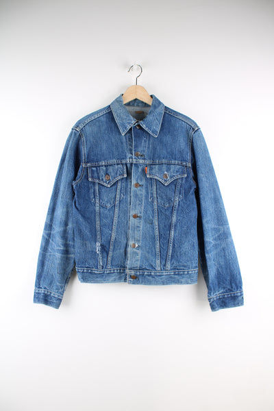 Vintage Levi's denim trucker jacket button up, double chest pockets, and has orange tab logo embroidered on the chest. 