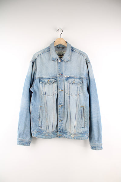 Vintage Guess light wash button up denim jacket, features embroidered spell-out details across the back 