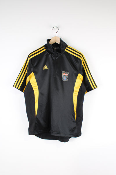Adidas Manchester Hockey Jersey. Black short sleeve t-shirt with high neck and 1/4 zip. Features yellow three stripe detail and embroidered Adidas logo. The t-shirt has a printed logo for a Manchester hockey team and number 12 on the back.  good condition   Size in Label:  Mens M