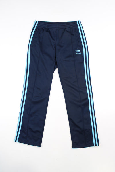 Vintage 90's navy blue Adidas tracksuit bottoms with blue embroidered logo and three stripe detail down the legs. Also features an elasticated waistband and front seam detail.  good condition Size in Label: 36" - Measure like a womens M