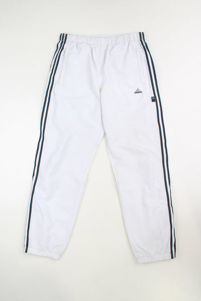 Vintage white Adidas tracksuit bottoms with elasticated waistband and 1/4 zips on the side of the ankles. Features embroidered logo and three stripe detail on the leg. good condition - Mark on the cuffs (see photos) Size in Label: Mens M - Measures like a L