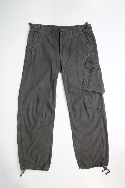 Y2k Nike low rise, grey, wide leg cargo trousers. Features adjustable straps at the waist to slightly adjust the fit and embroidered Nike logo on the leg.  good condition   Size in Label:  Womens M - Measures more like a womens XL