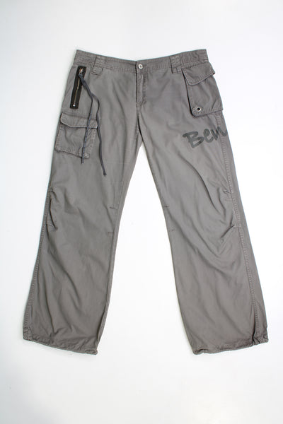 Y2k Bench low rise, grey, wide leg cargo trousers. Feature printed Bench logo on the leg and zips with long pulls on them.  good condition   Size in Label:  34 (XL)