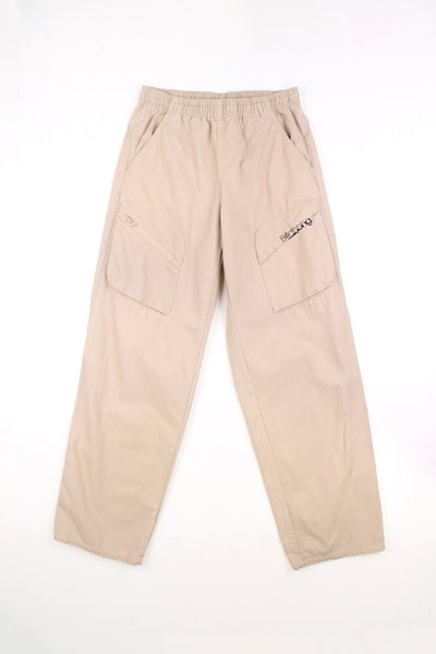 Billabong tan cotton trousers, with high waist and cargo style pockets. Features embroidered logo on the leg 