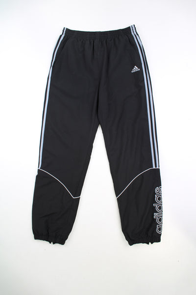 Vintage black Adidas tracksuit bottoms with elasticated waistband and 1/4 zips on the side of the ankles. Features embroidered logo and three stripe detail on the legs. good condition - mark on the back of the leg (see photos)Size in Label: 34 - Measures like a Mens L