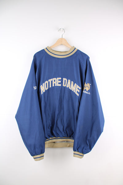 Vintage Notre Dame blue nylon pullover training top, with embroidered spell-out details across the chest and shoulders 